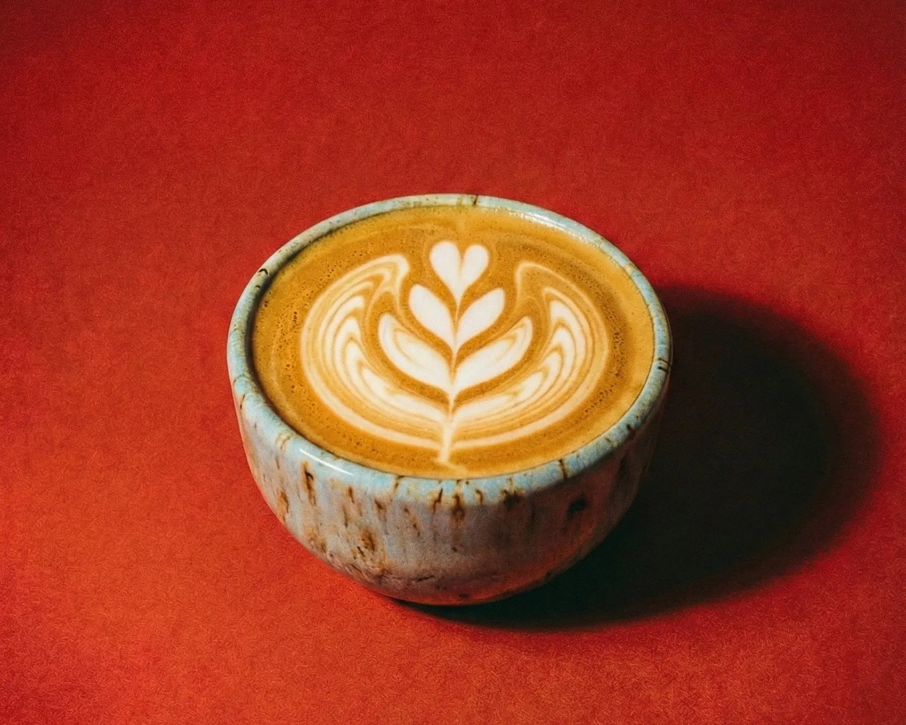 Flat white coffee made with organic coffee beans using the clayman blue ceramic coffee cup.